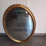 Large and elegant oval gilded mirror with its beveled glass