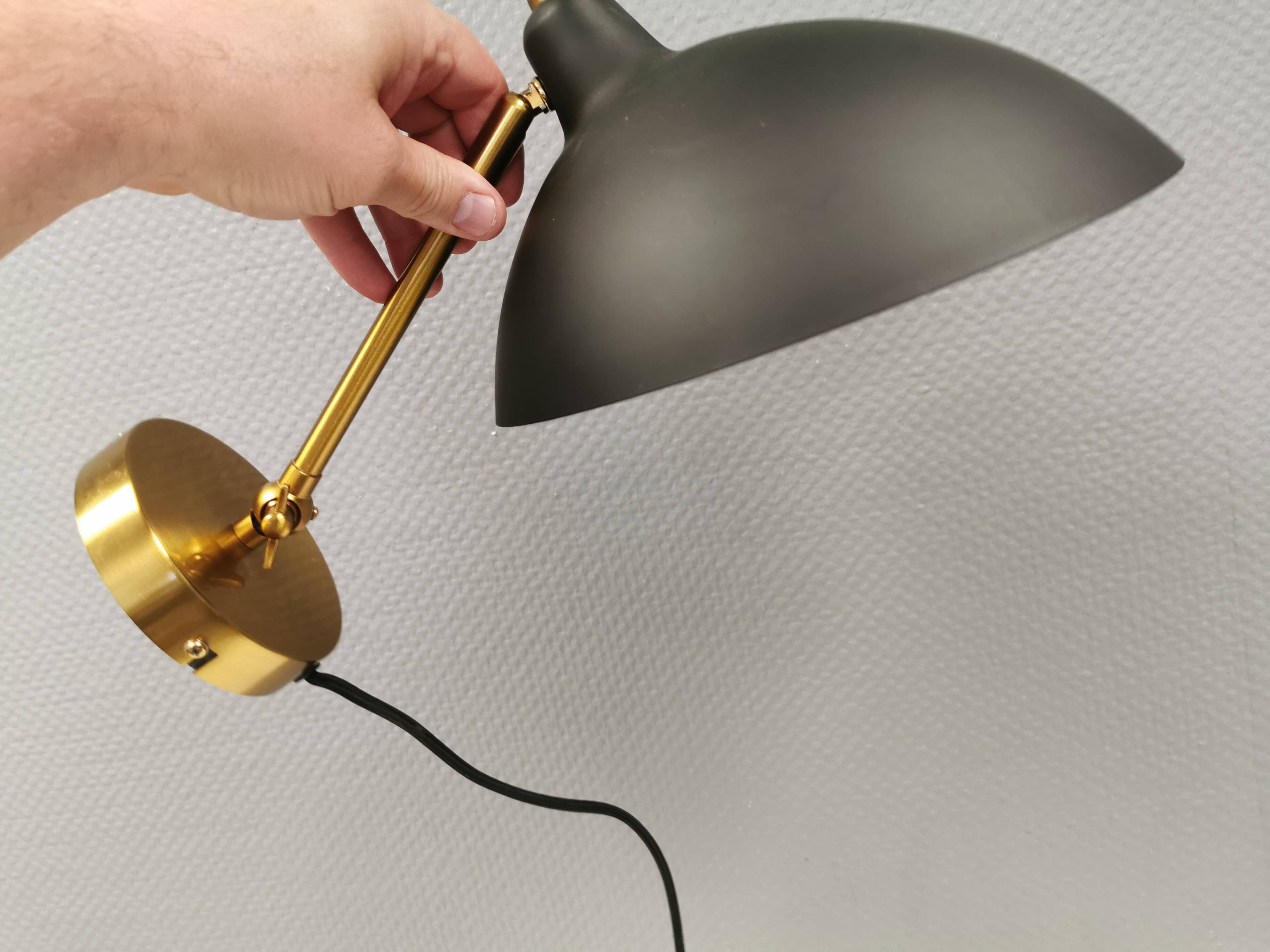 A wall lamp in black and brass-coloured finishes. Danish, early 2000s.