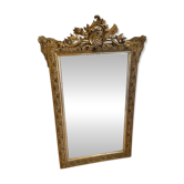Large gilded antique mirror with a sculpted pediment.