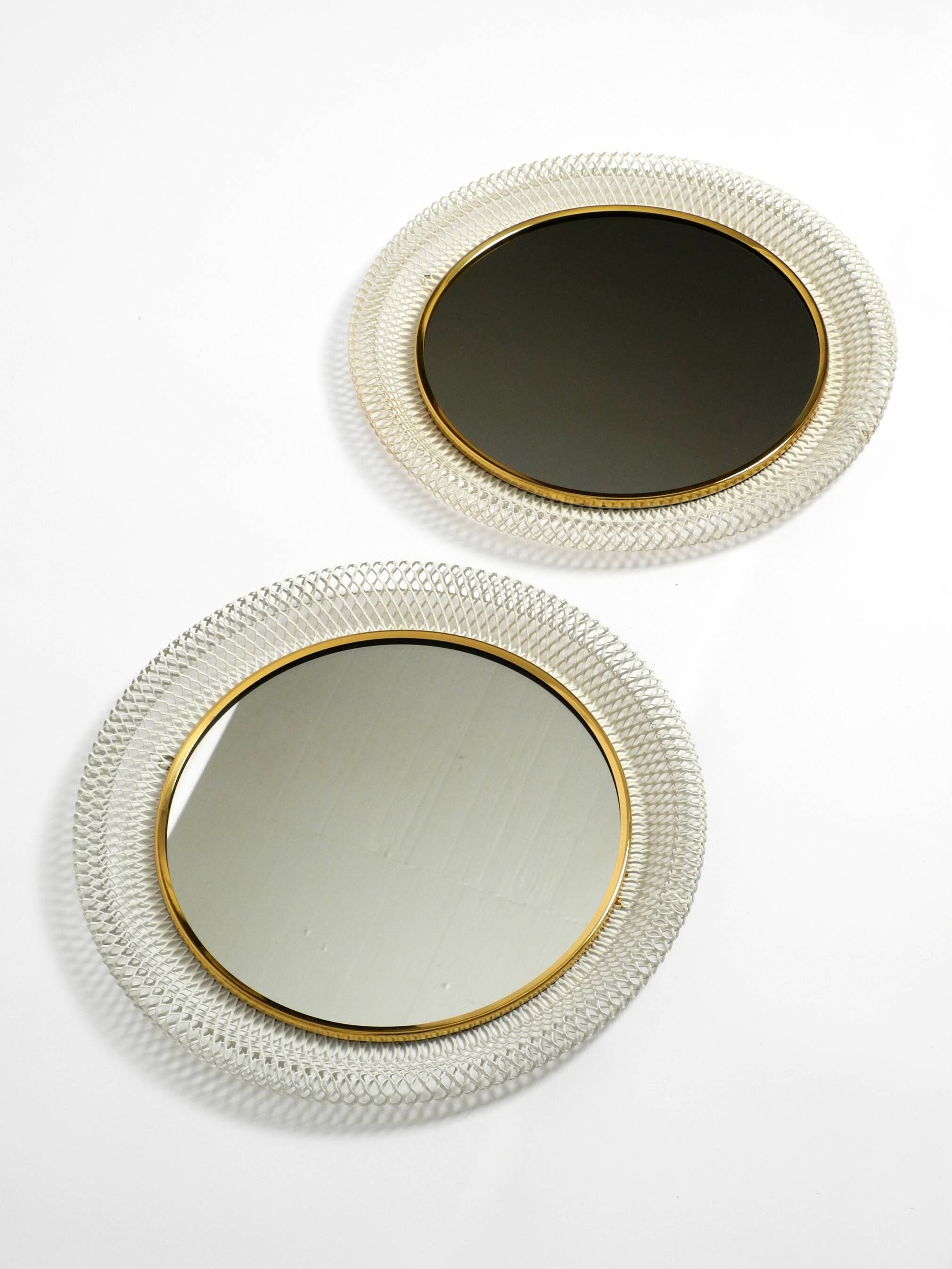 Pair of Mid Century wall mirrors with brass rim and white metal frames