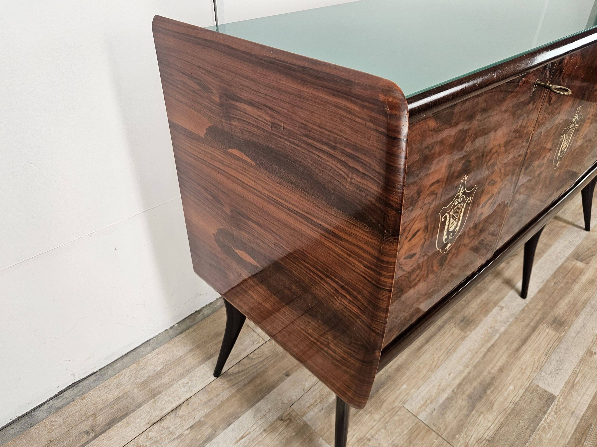 Mid-century mahogany buffet with teal glass and compartments with a drawer.