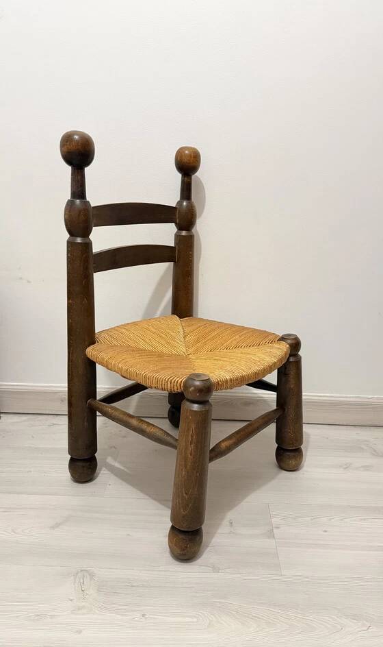 Low fireplace chair in the style of Charles Dudouyt – wood and straw seat.