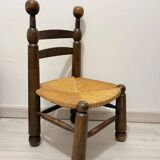 Low fireplace chair in the style of Charles Dudouyt – wood and straw seat.