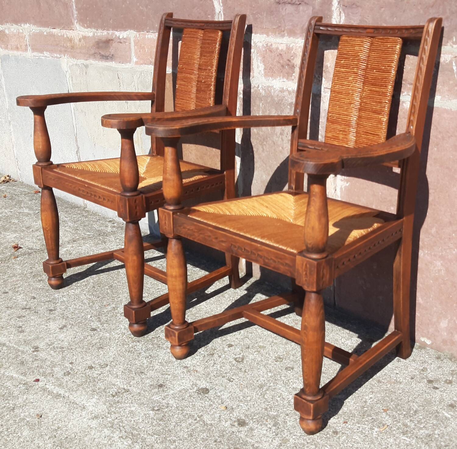 Pair of oak armchairs with straw seats and backs.