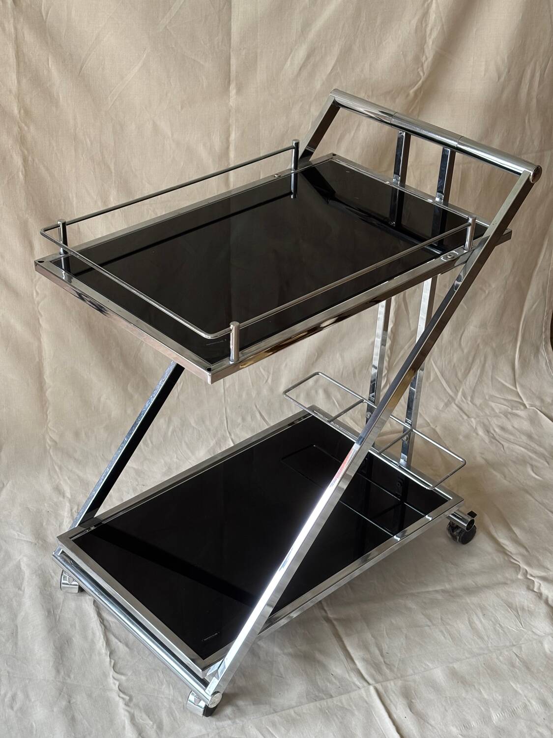 Modernist serving trolley in chromed metal and black smoked glass