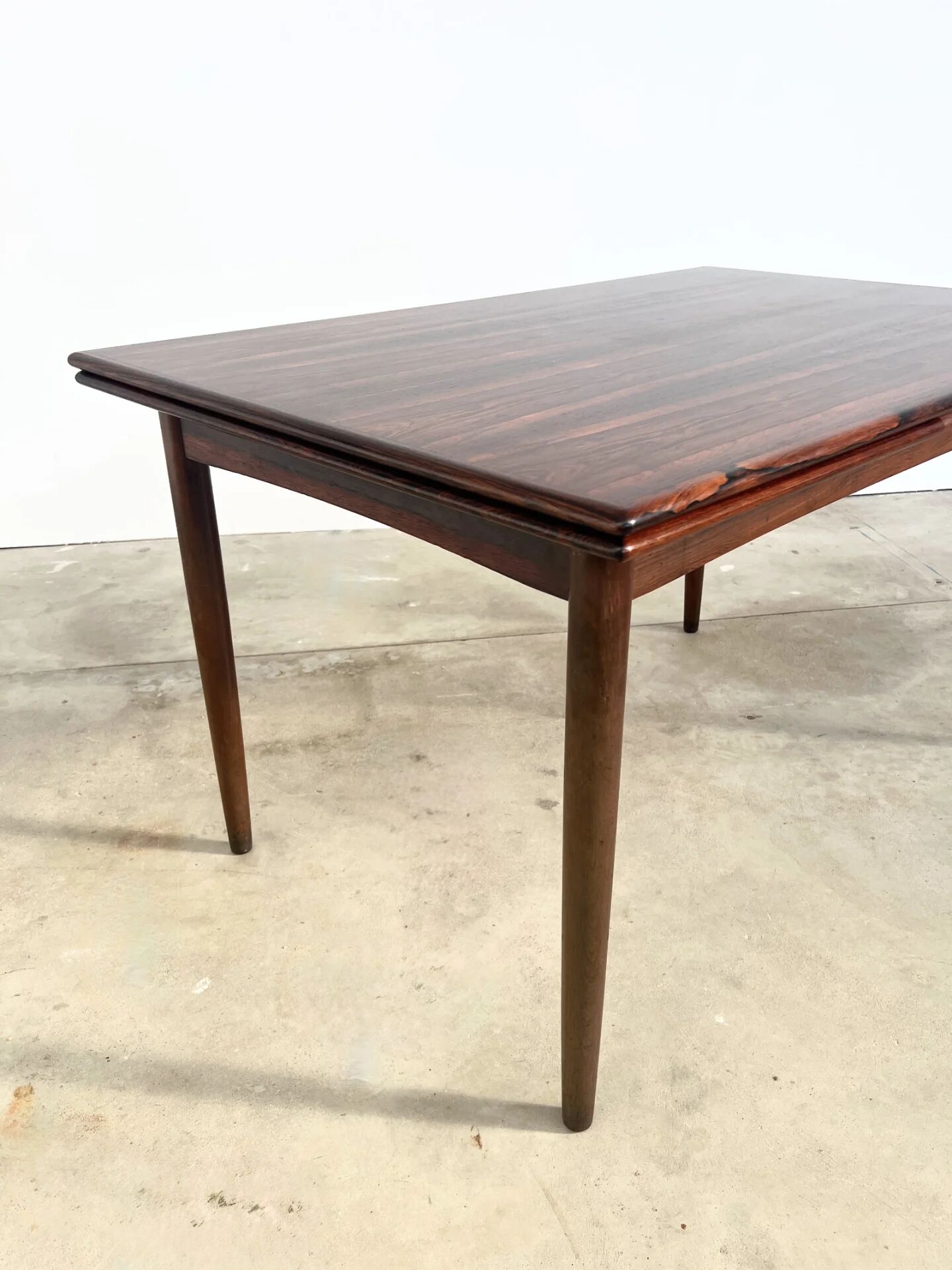 Rosewood dining table with integrated extensions — Denmark, 1960s