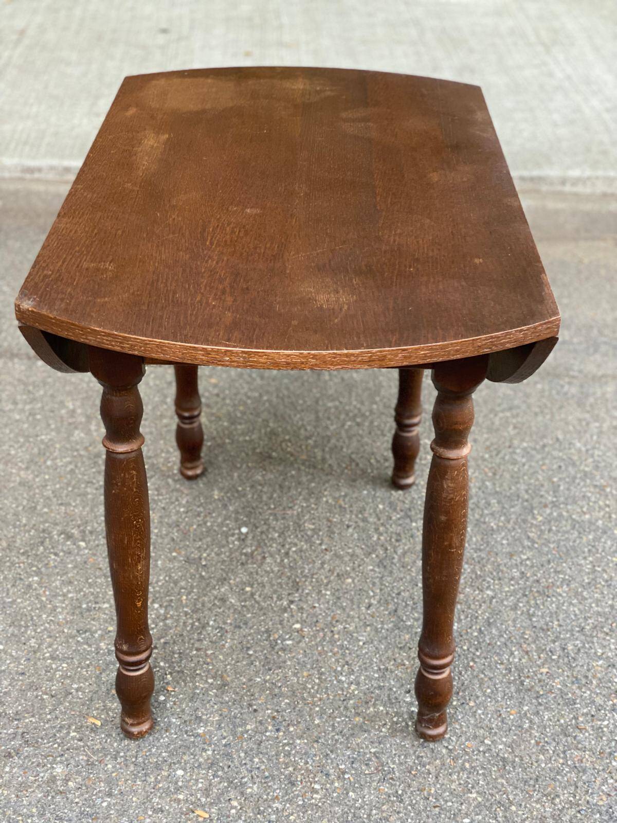 Round kitchen or dining table with extendable leaves in dark wood.