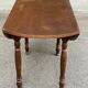 Round kitchen or dining table with extendable leaves in dark wood.