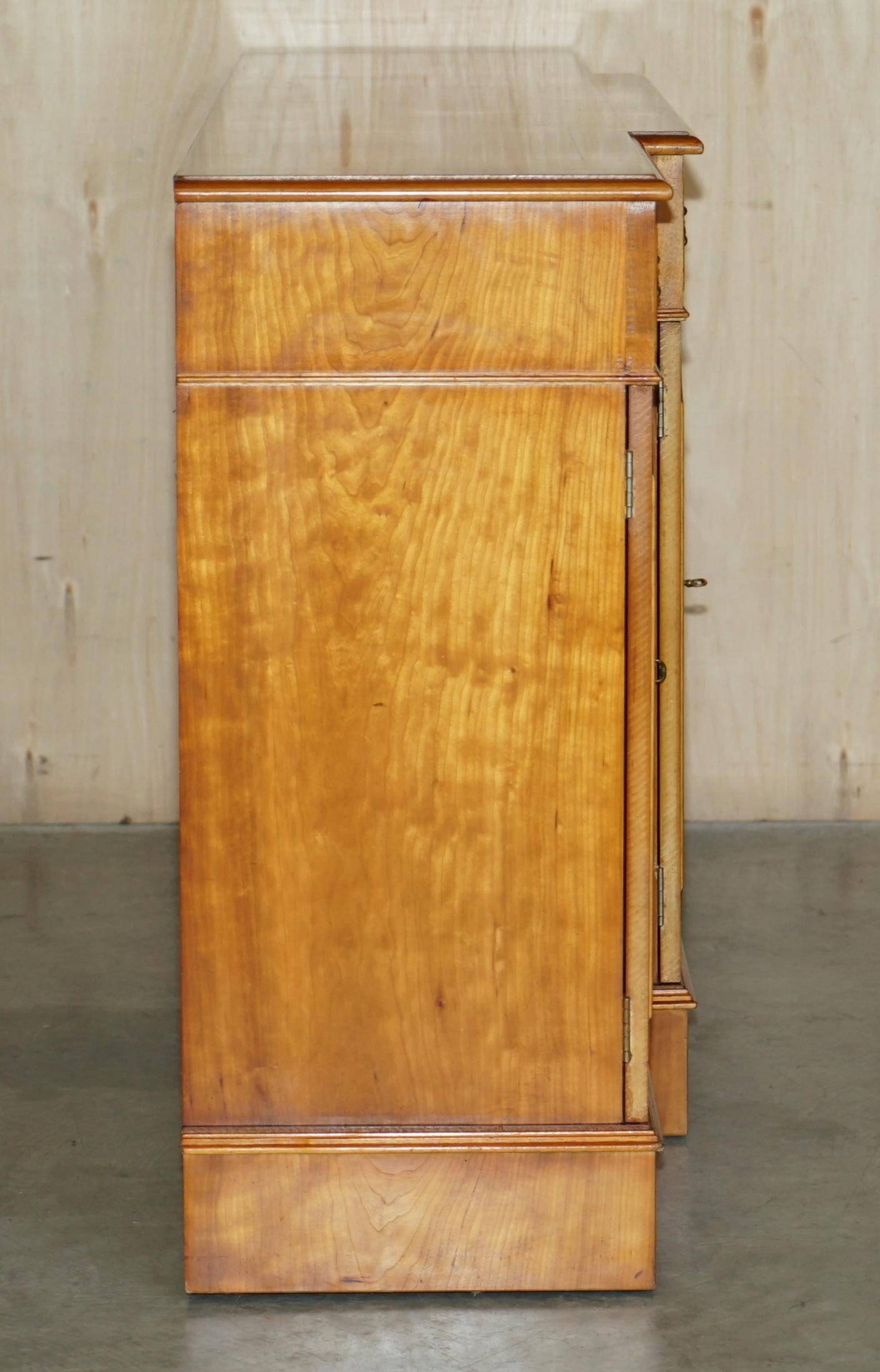 Vintage buffet made of mottled yew wood with three doors and four drawers.