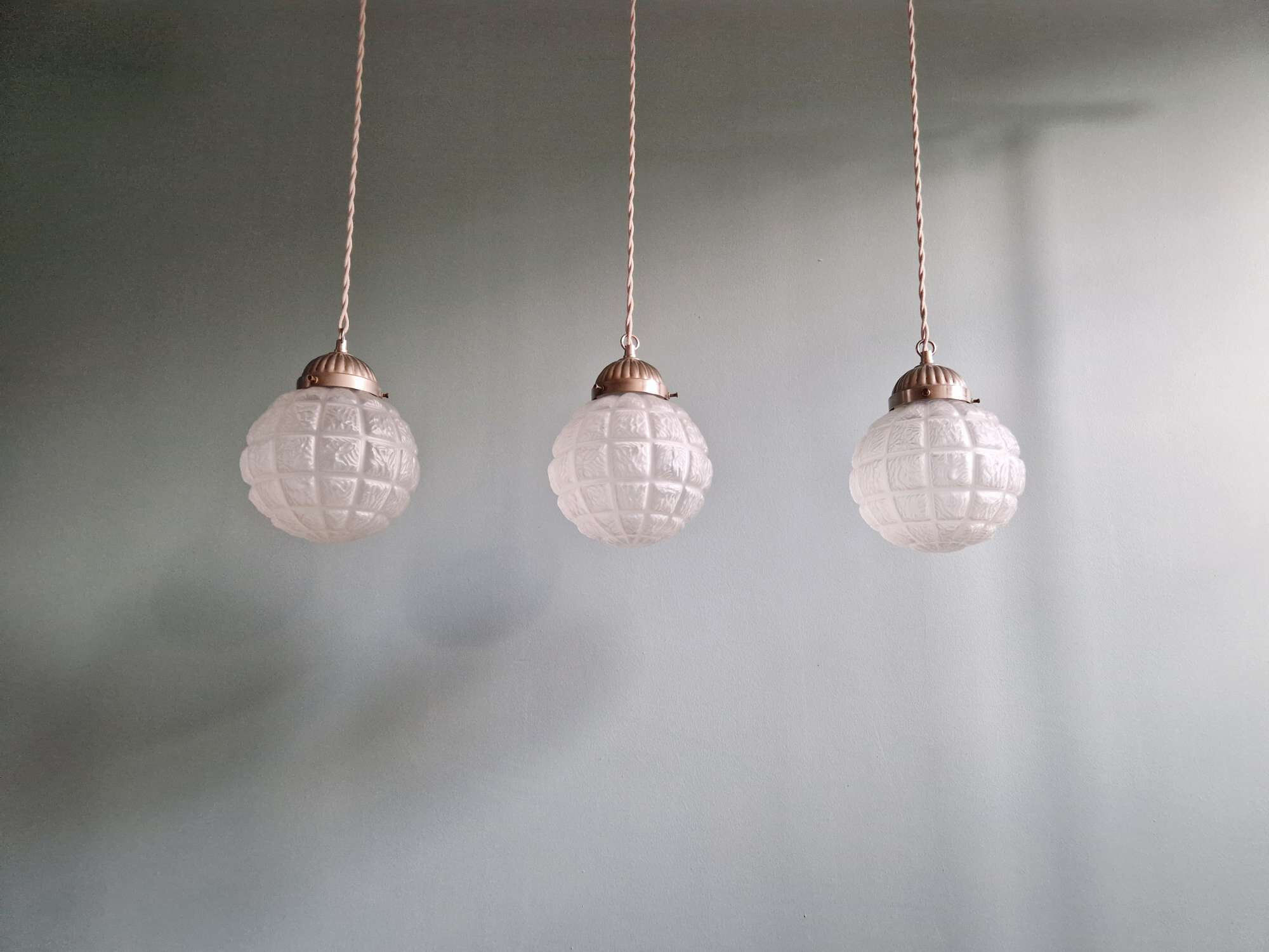 Art Deco trio of frosted glass pendants, 1920s-30s.