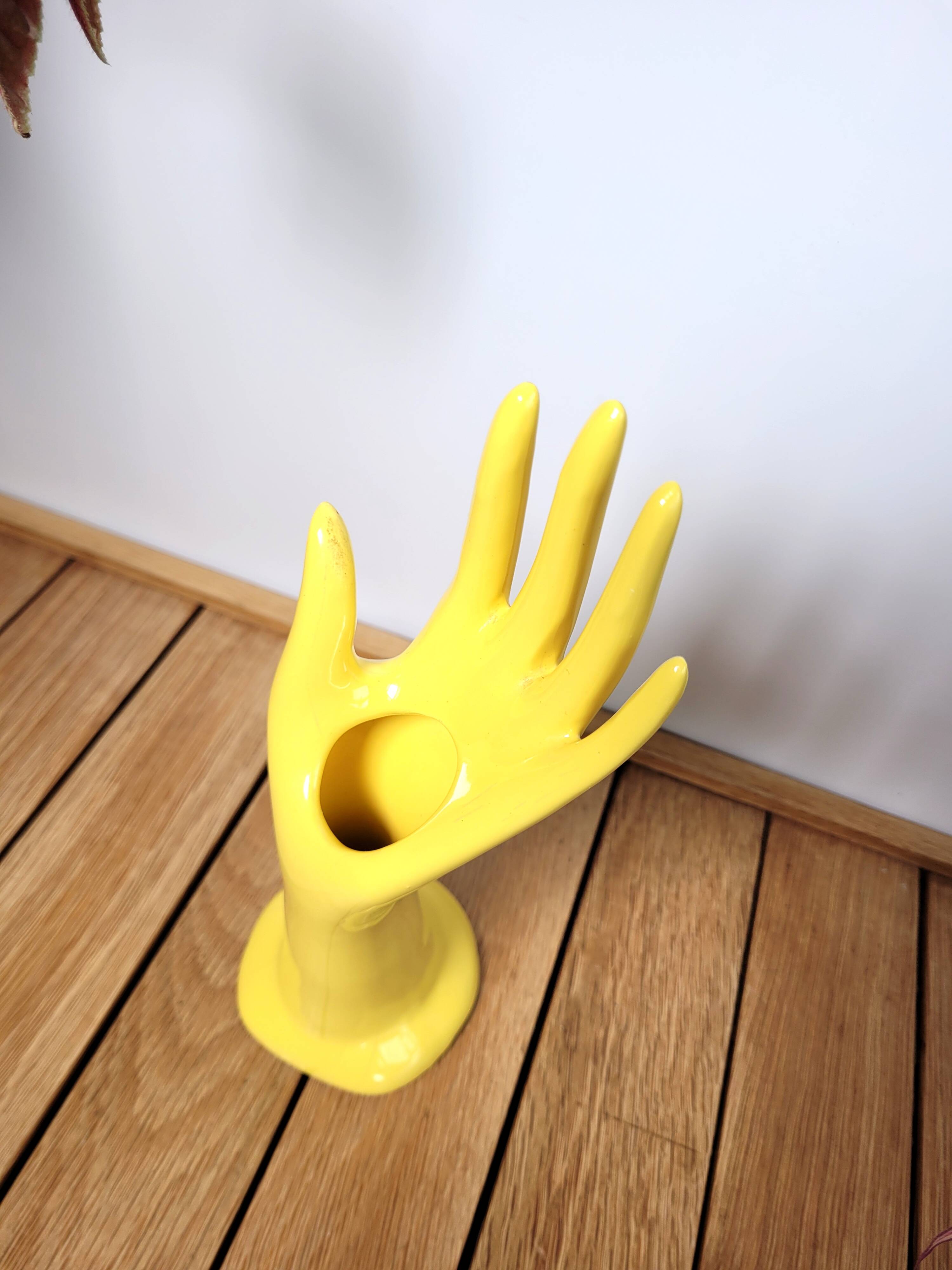 Hand wears ring and yellow soliflore