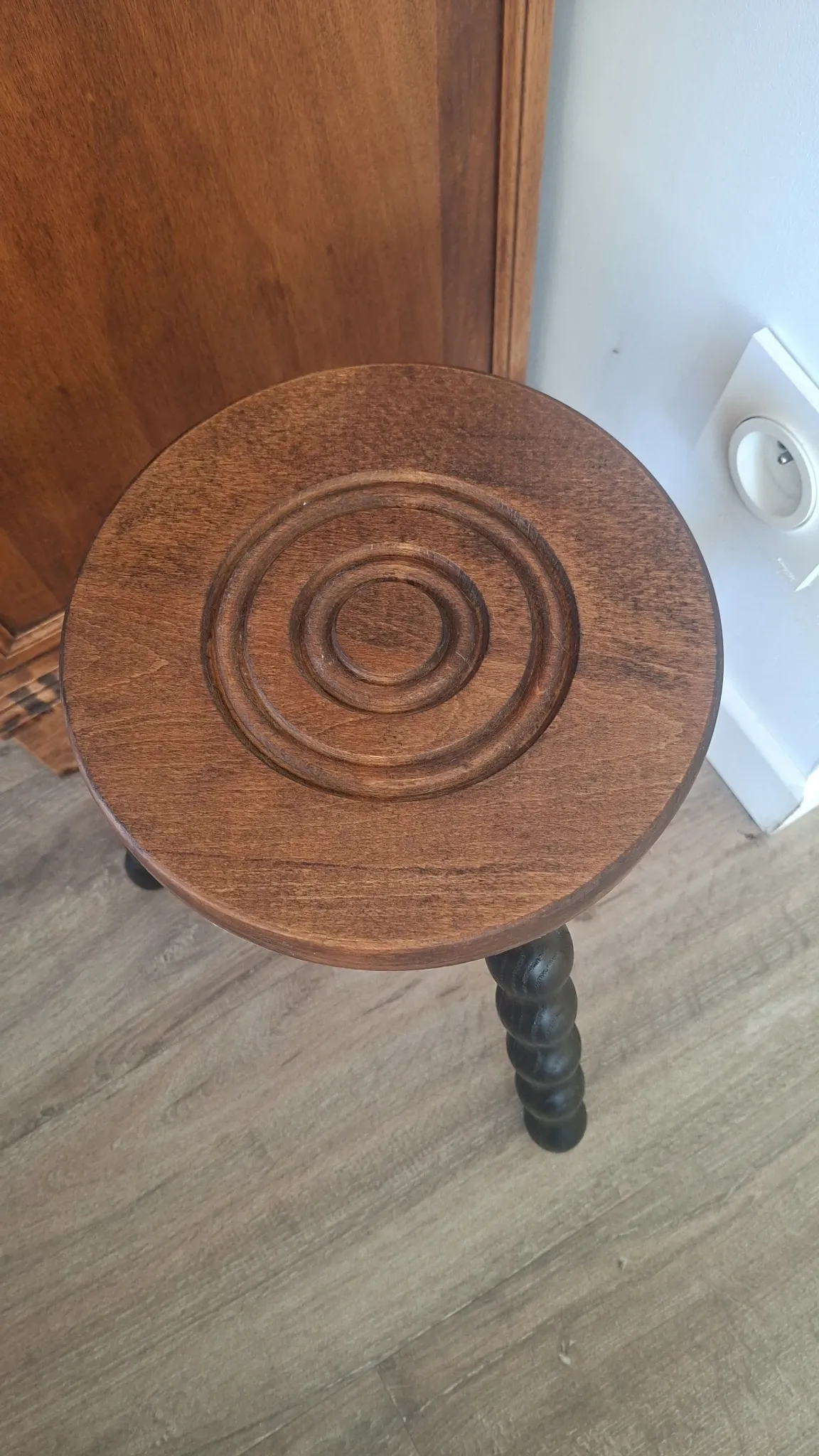 Brown and black wooden tripod stool