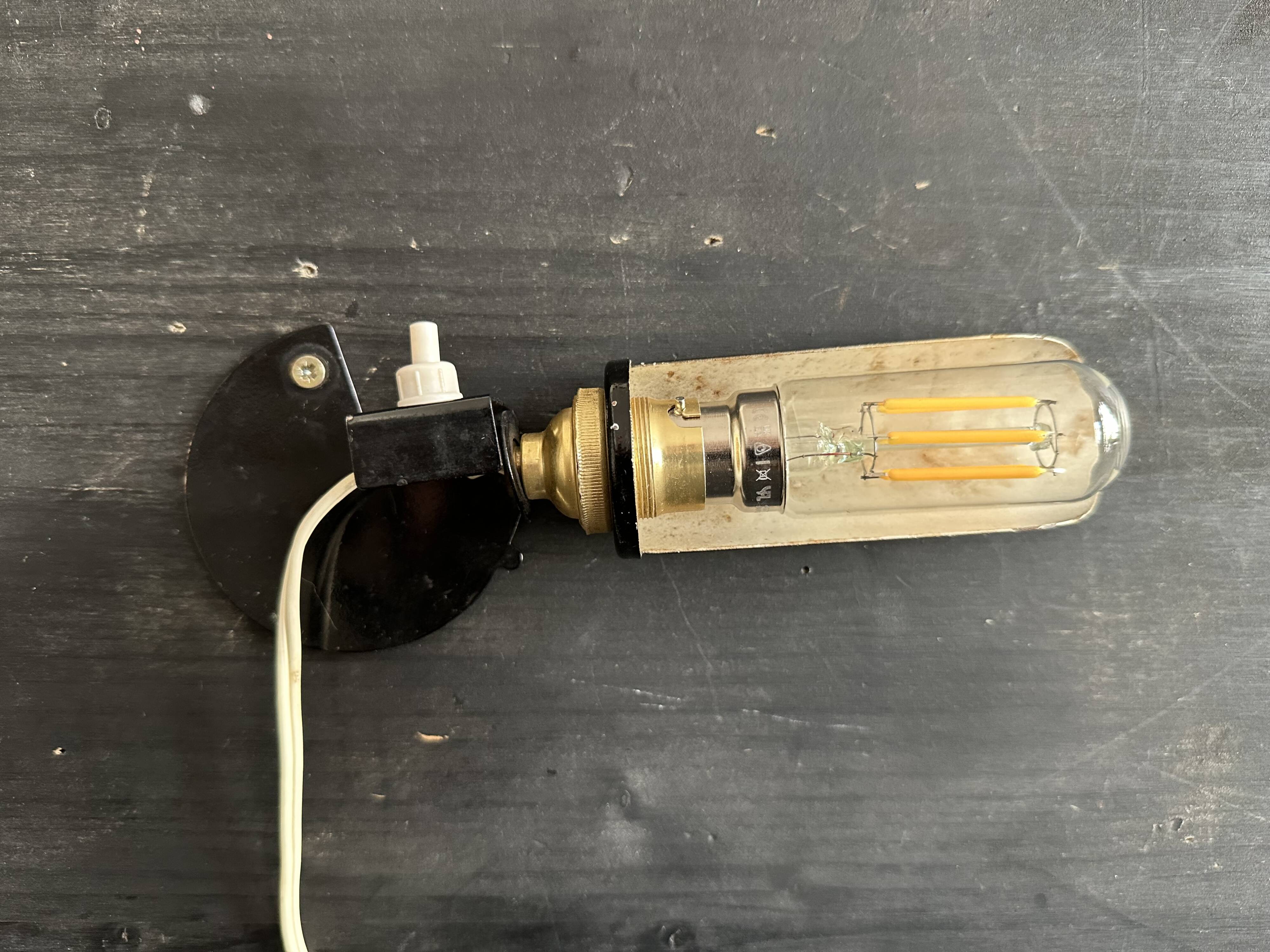 Old black metal and brass wall light, adjustable, 1930s.