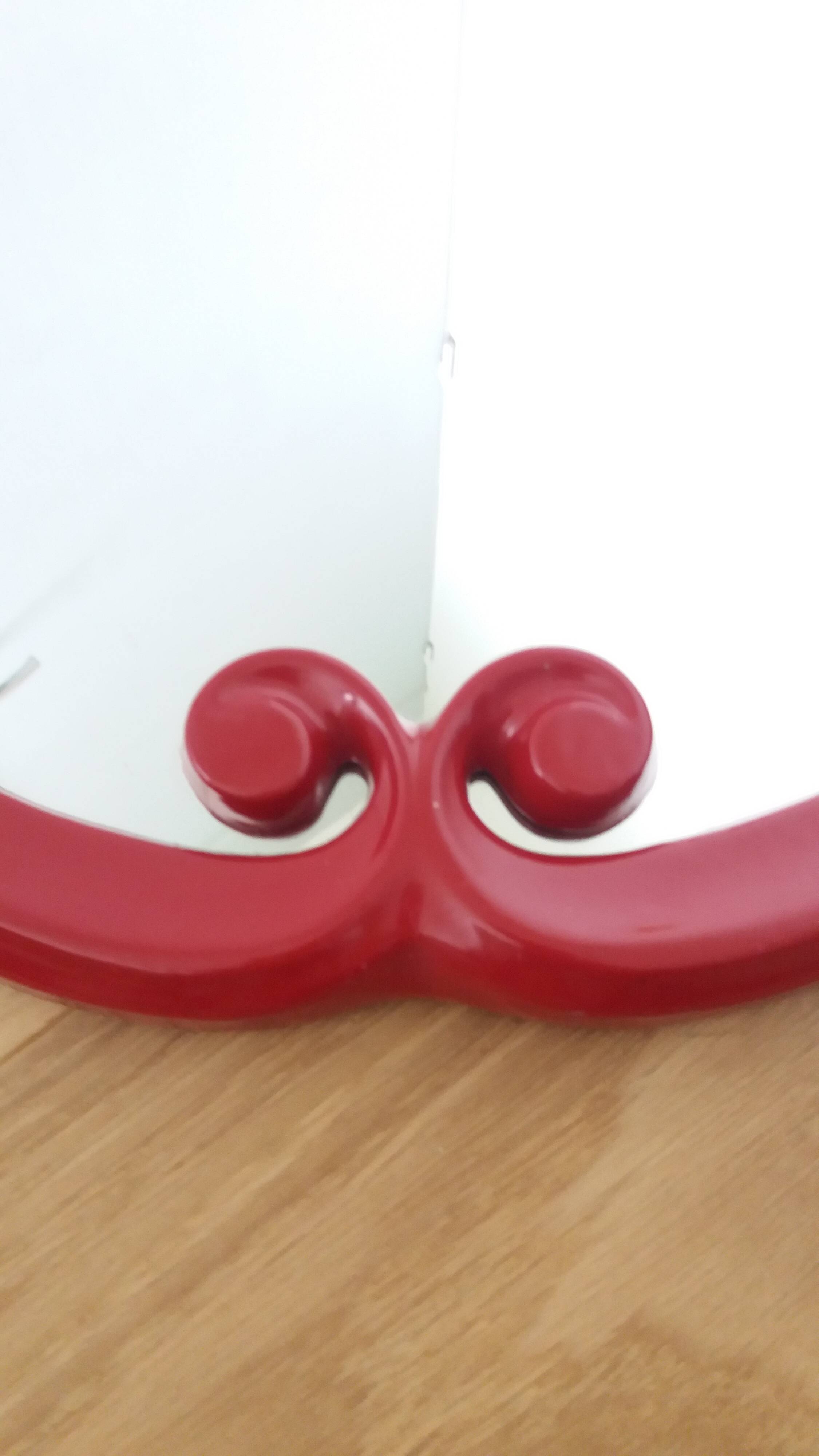 Oval mirror, red enamelled metal in Art Deco style, 49 x 39 cm.