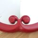 Oval mirror, red enamelled metal in Art Deco style, 49 x 39 cm.