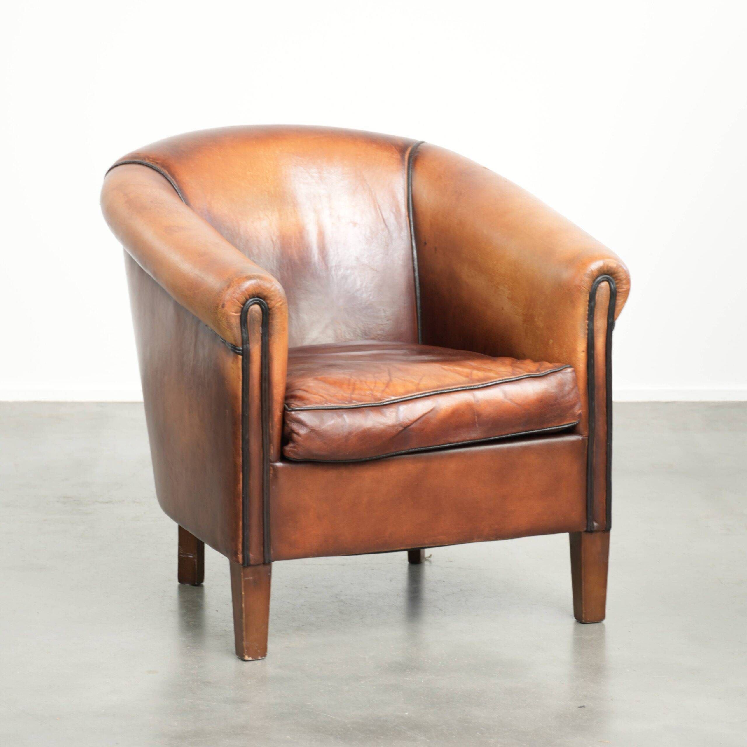 Vintage sheepskin club armchair finished with black piping