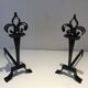 Important pair of wrought iron andirons with torch in heraldic fleur-de-lis design.