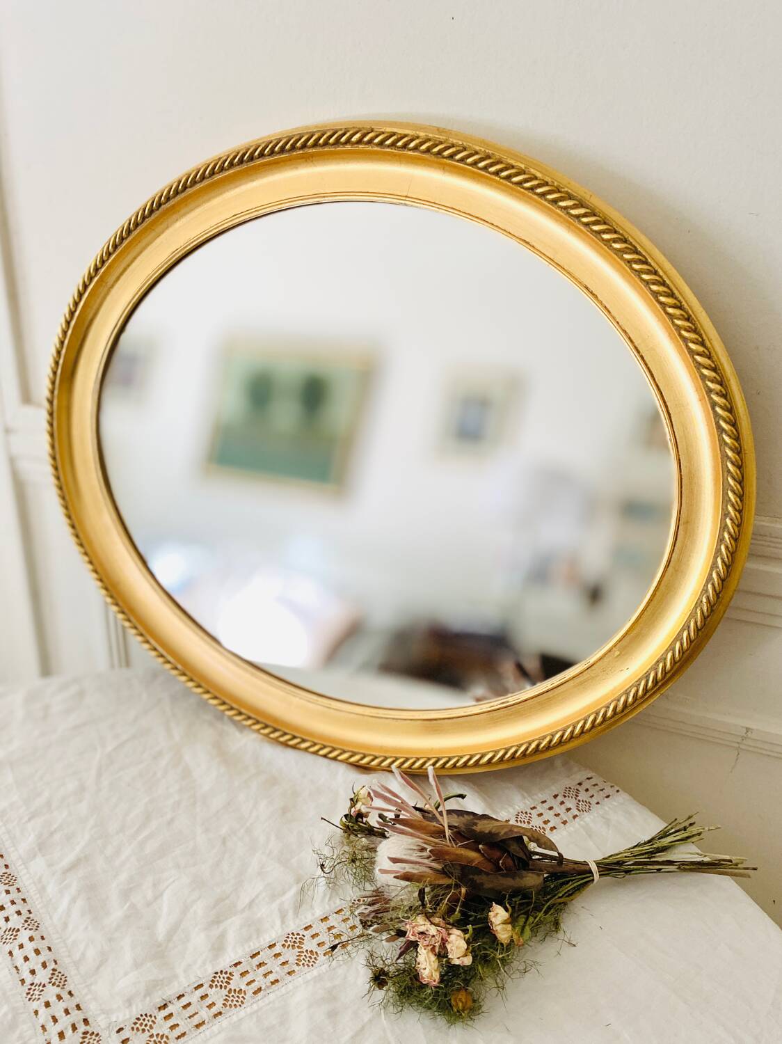 Oval wall mirror in gilded wood