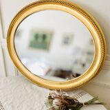 Oval wall mirror in gilded wood