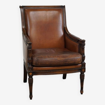 Offered is this lovely classic sheep leather armchair with wood carving and a good patina
