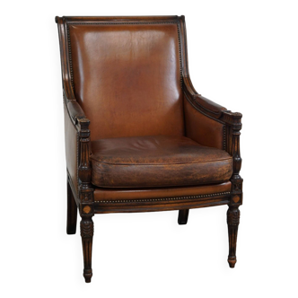 Offered is this lovely classic sheep leather armchair with wood carving and a good patina