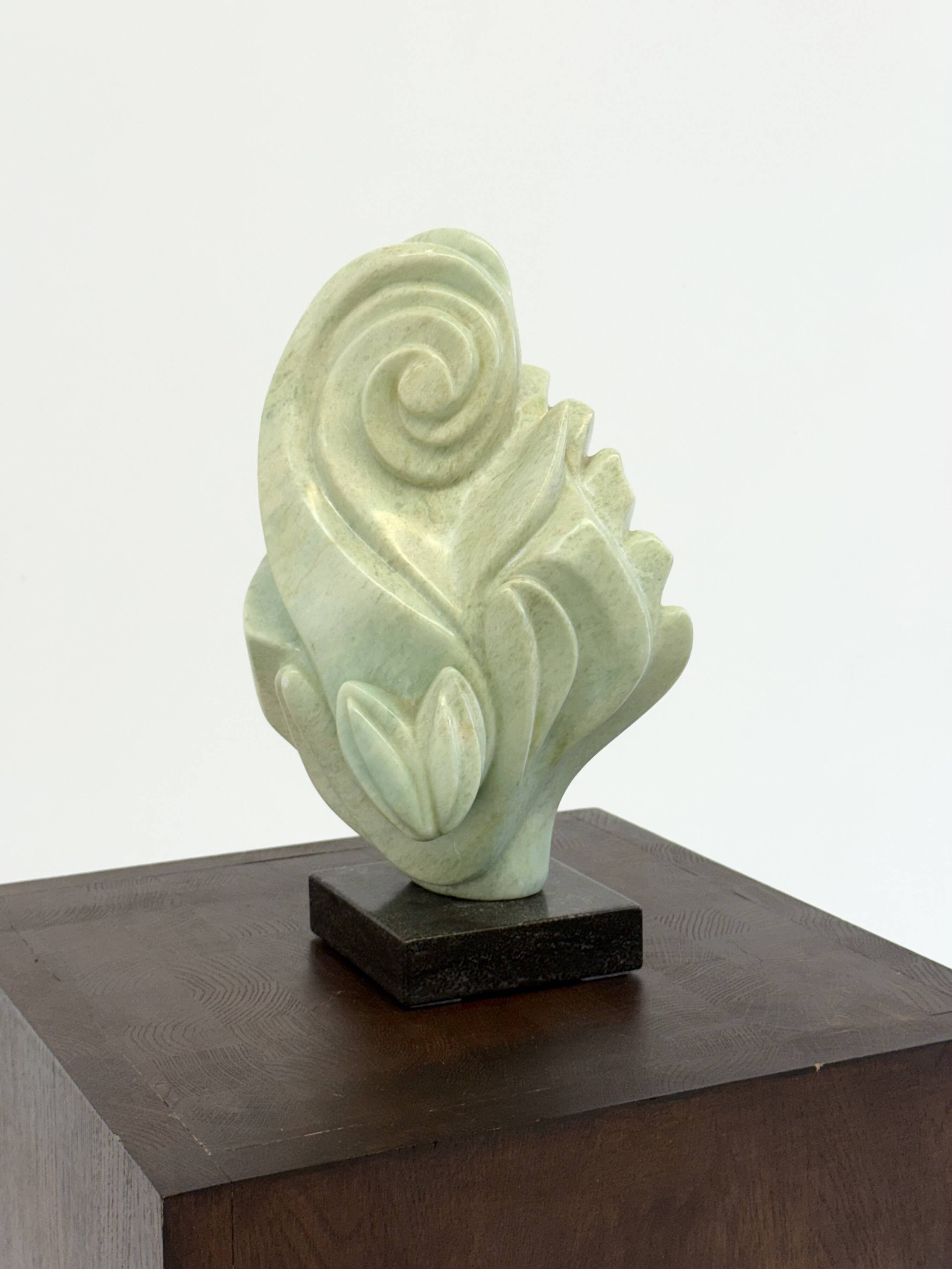 Green natural stone sculpture on marble base