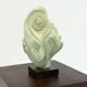 Green natural stone sculpture on marble base