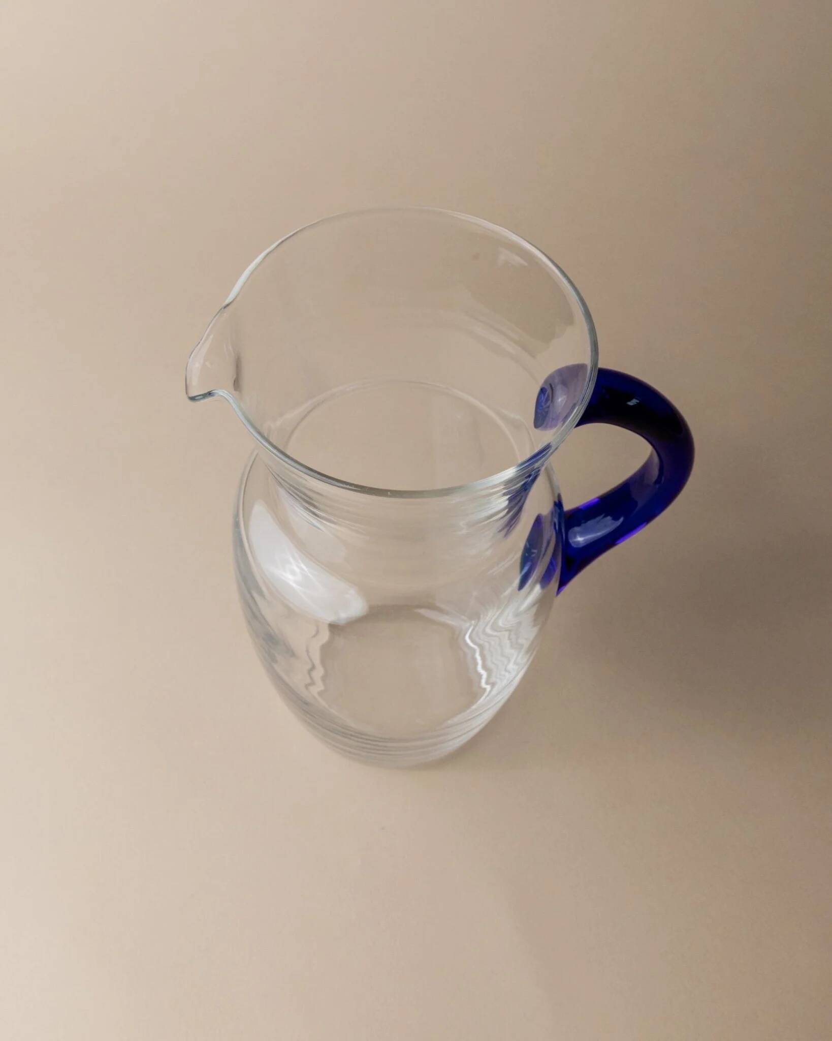 Vintage glass pitcher - clear glass with blue handle - Mid-Century design from Italy in the 1970s - elegant table decoration, retro gift idea.