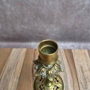 Antique brass candlestick with patina, openwork vintage foliage decoration.