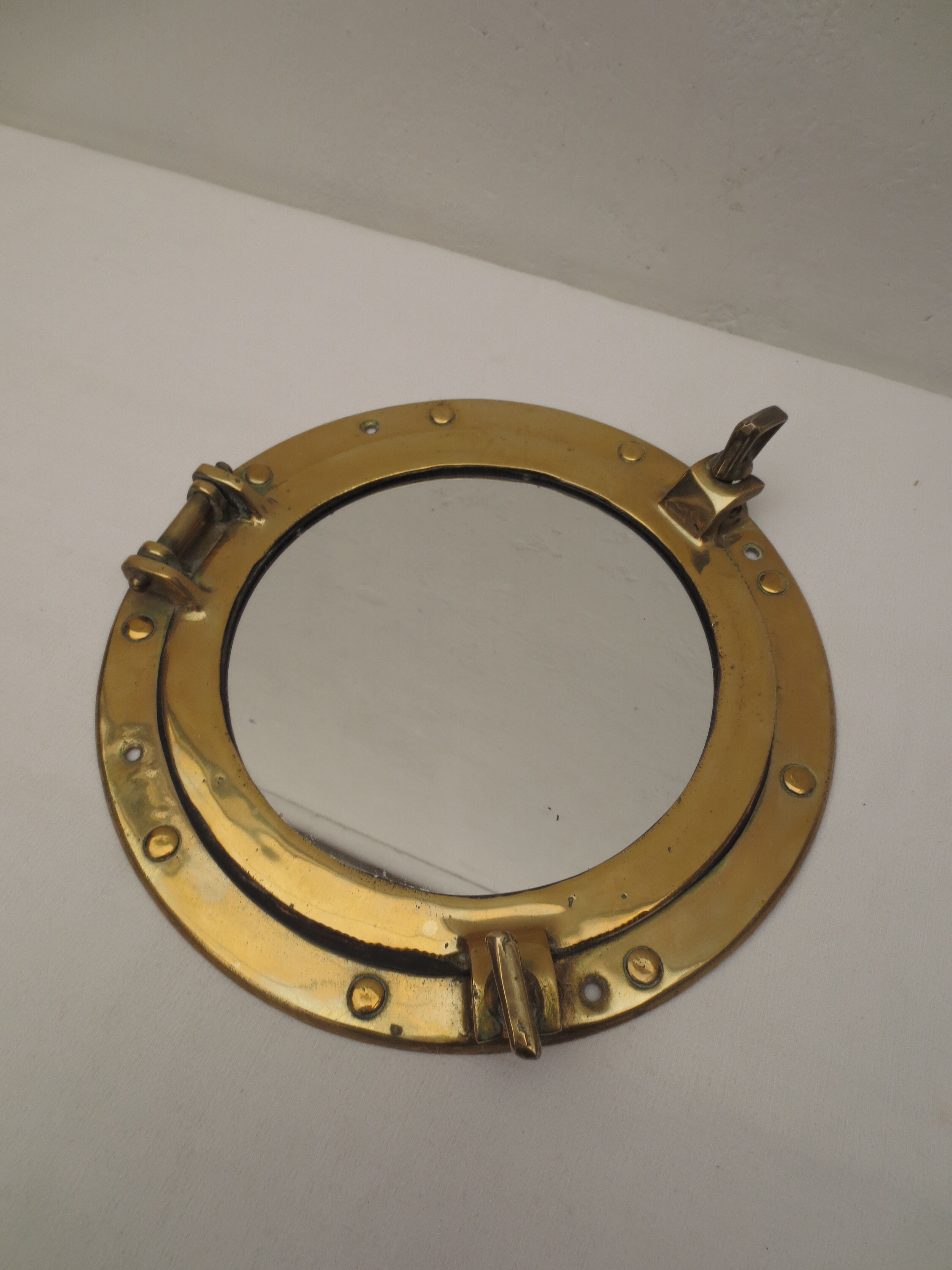 Mirror integrated into a brass navy porthole