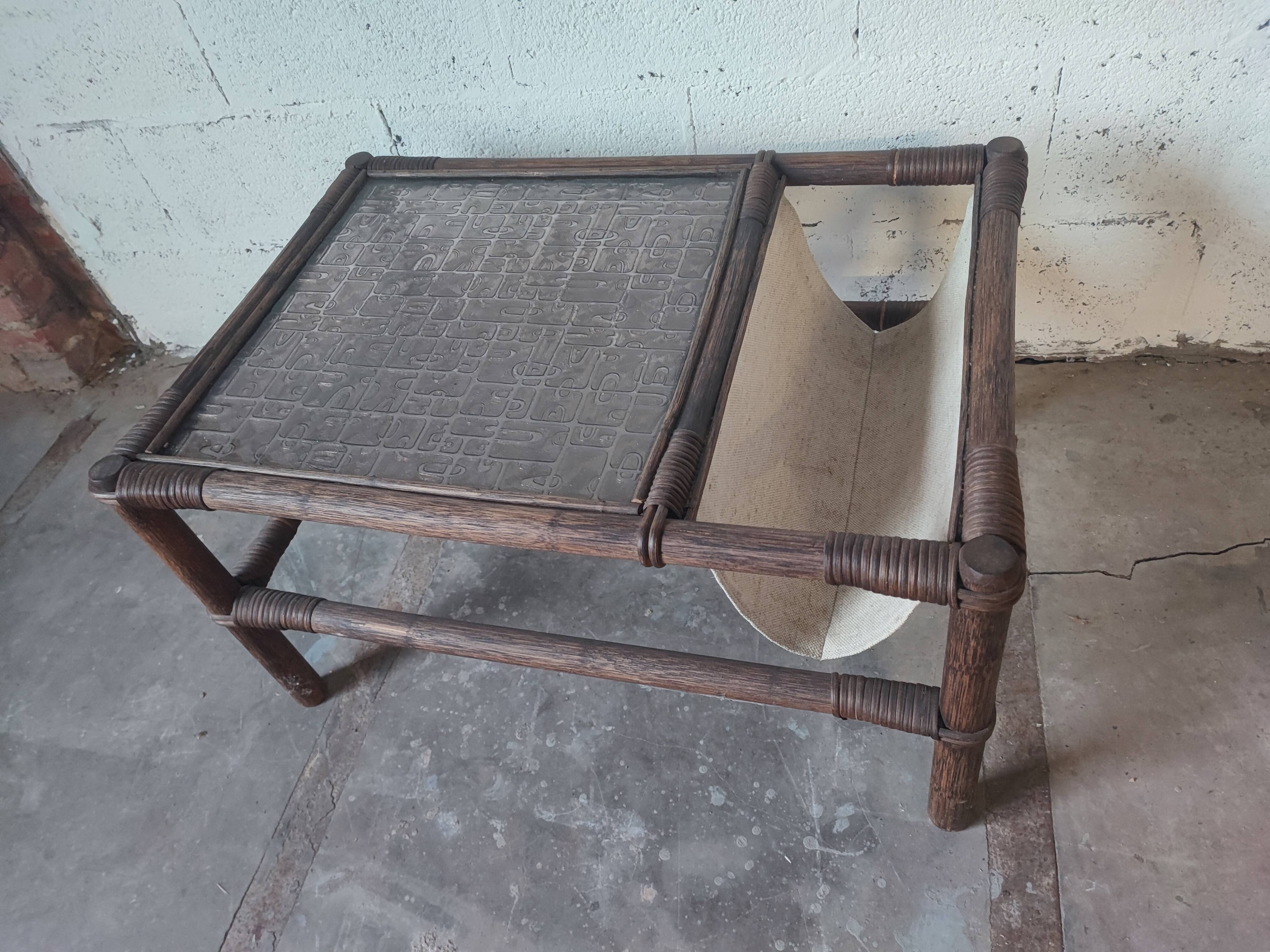 Relaxed armchair in bamboo and rattan with its small side table. Beige linen cushion.