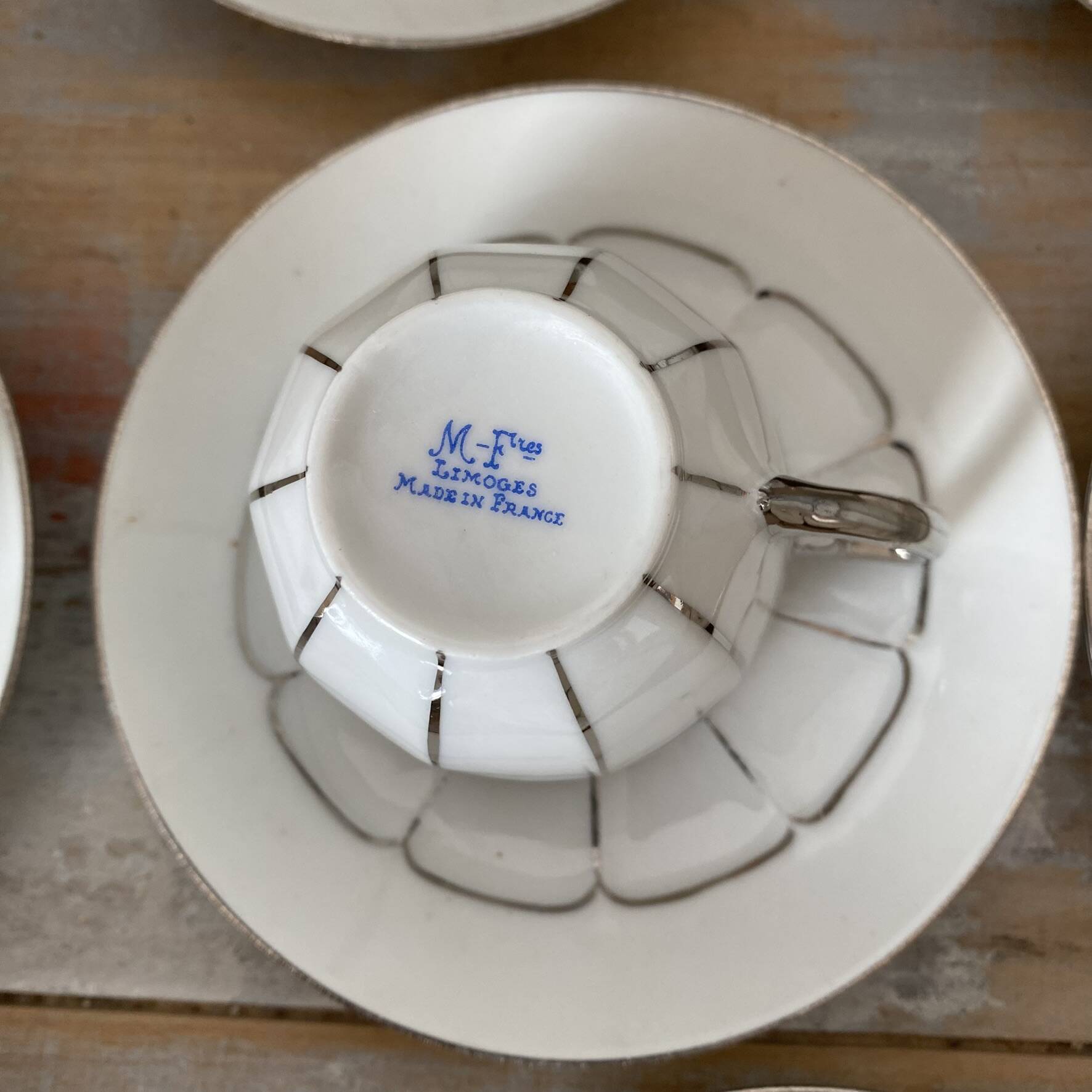 White and silver Limoges porcelain coffee cups and saucers.