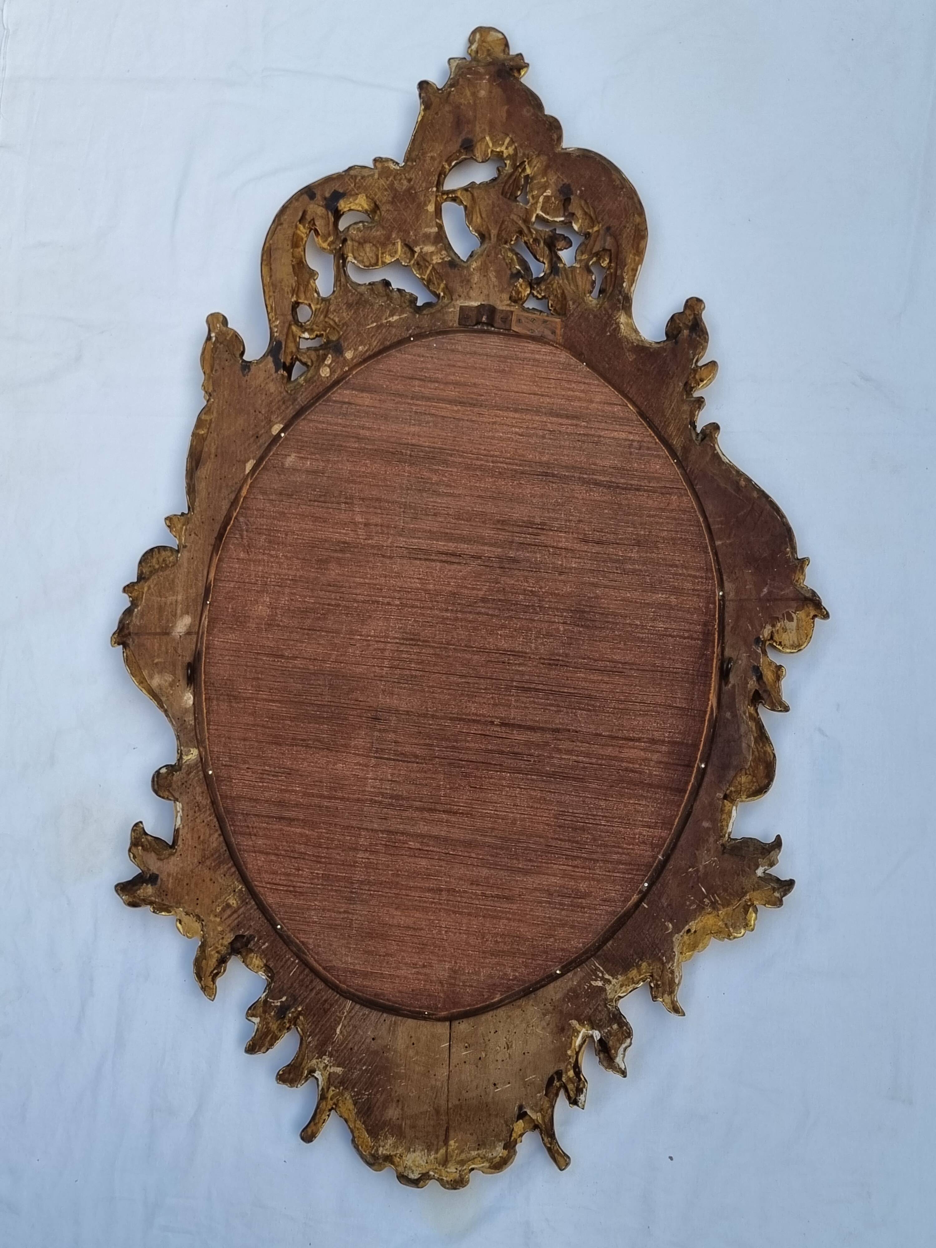 Large oval gold mirror, Louis XV rococo style, late 19th century, 114 x 66 cm.