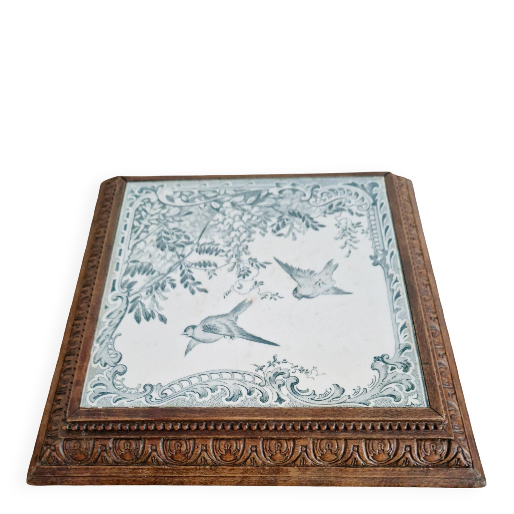 Antique musical trivet made of carved wood and Belle Époque earthenware.