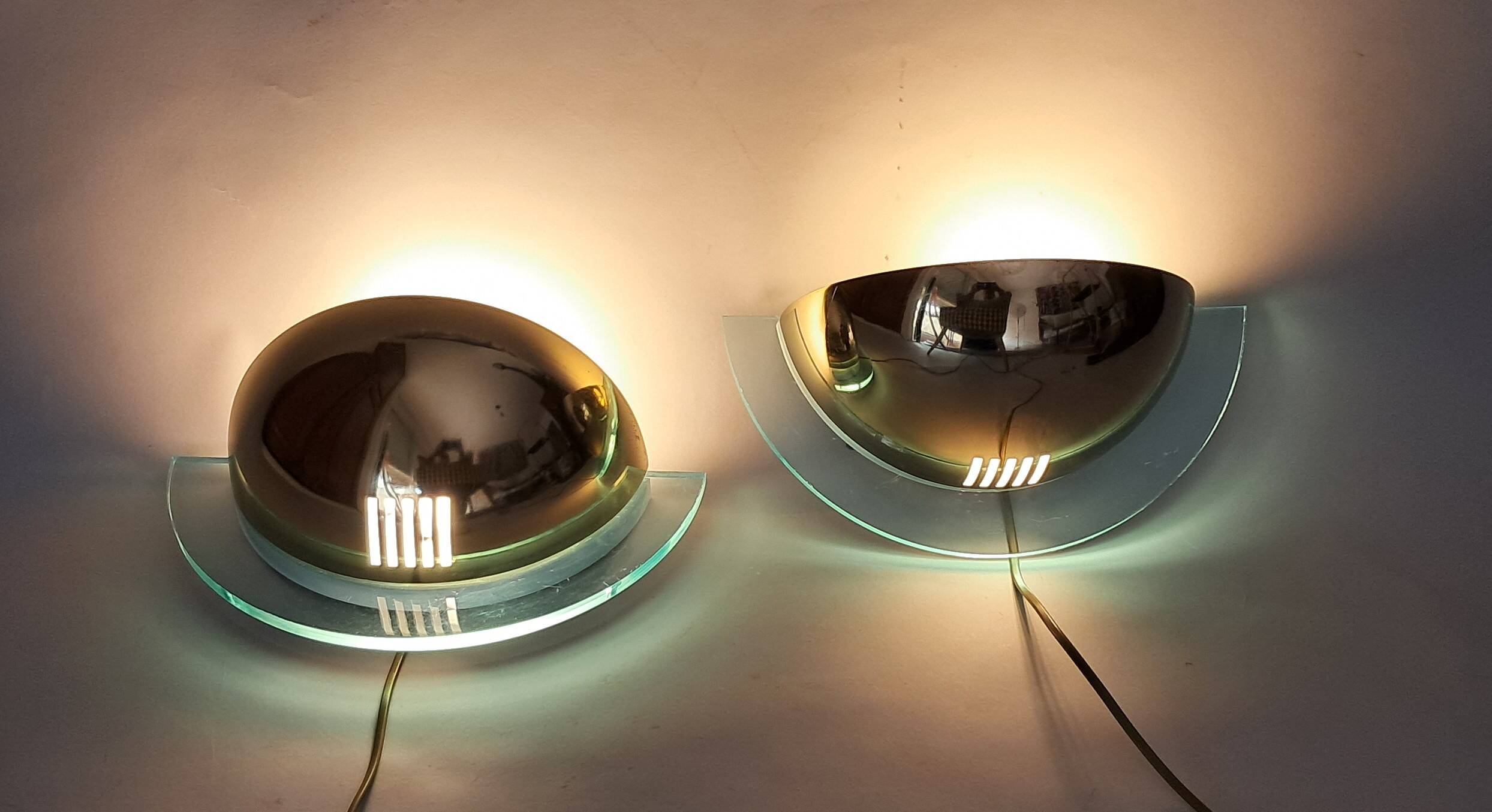 Pair of gold metal and plexiglass wall lights, circa 1980.