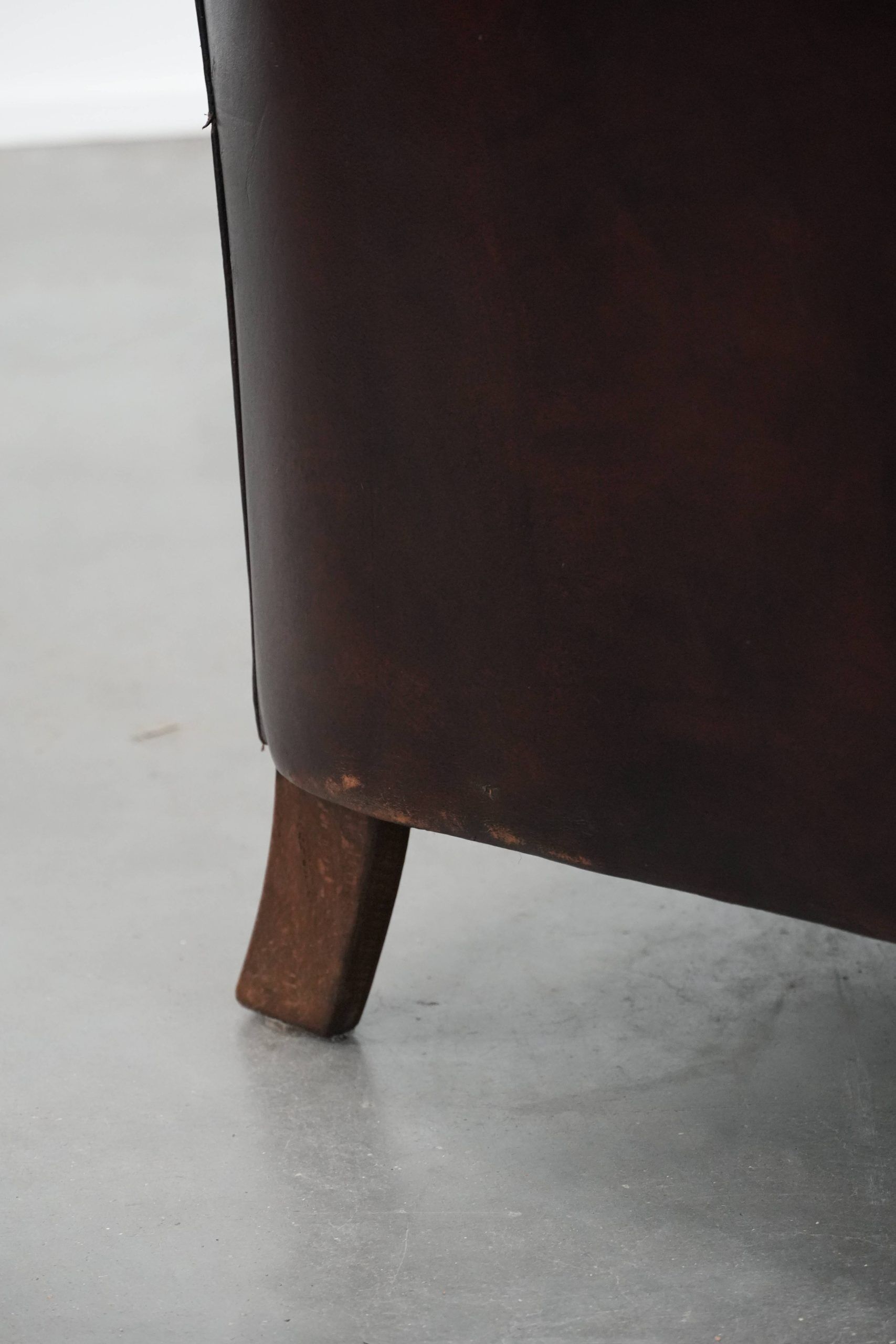 Stylish and sturdy dark brown club armchair made of sheepskin leather