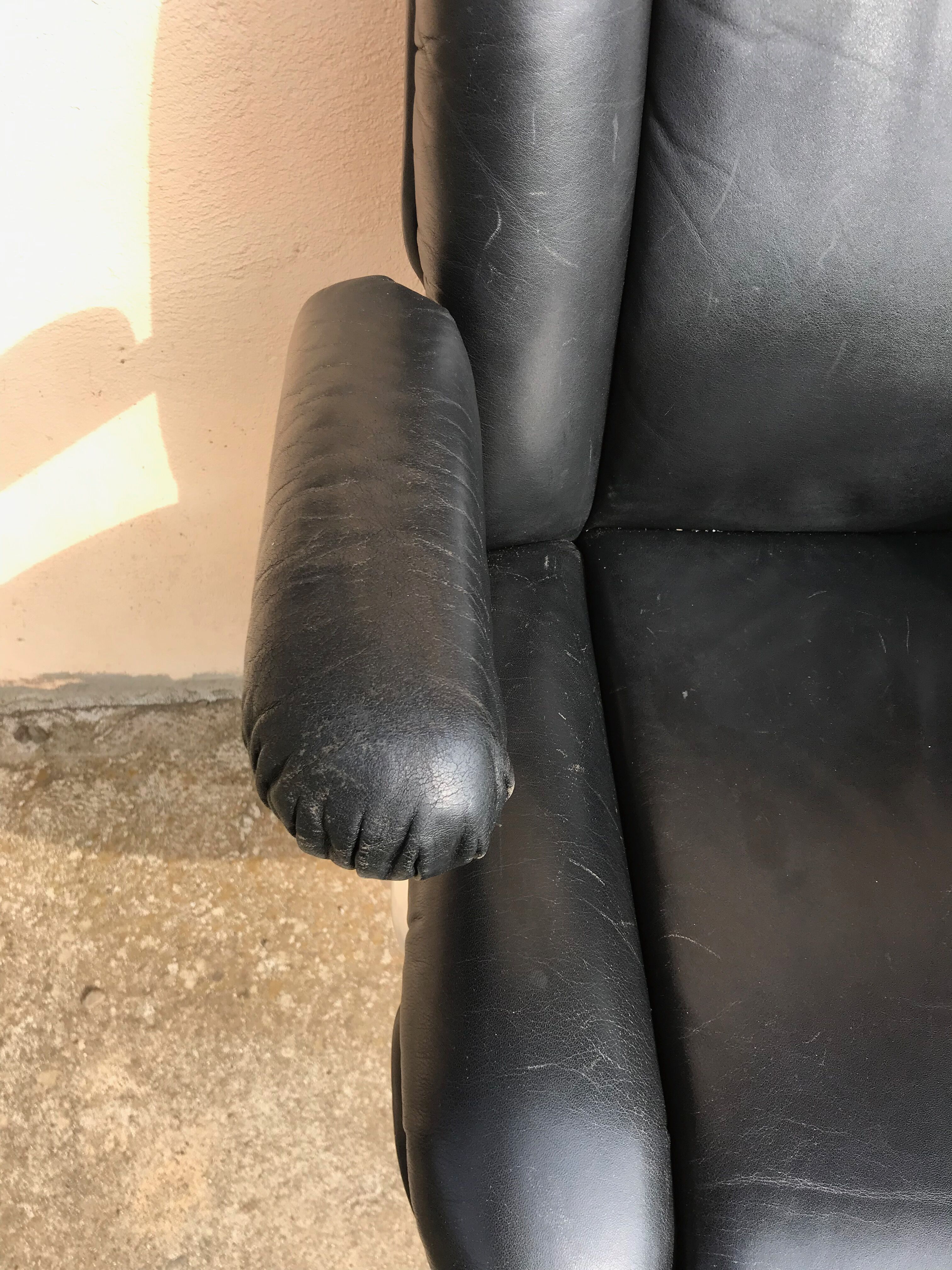 Vintage swivel black leather armchair