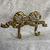 Two-hook coat rack with knot and ribbon in brass