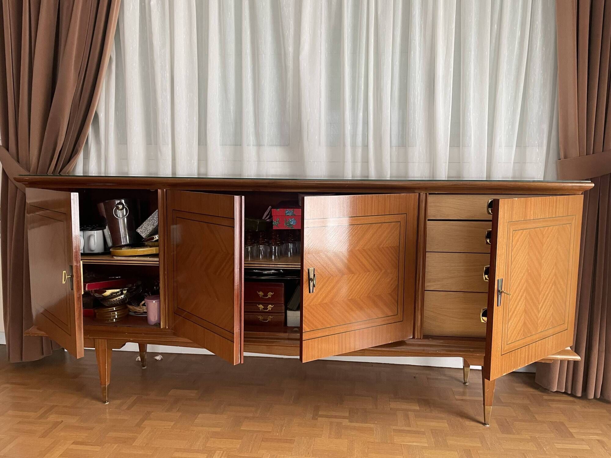 Vintage 4-door buffet with wood veneer and glass top.