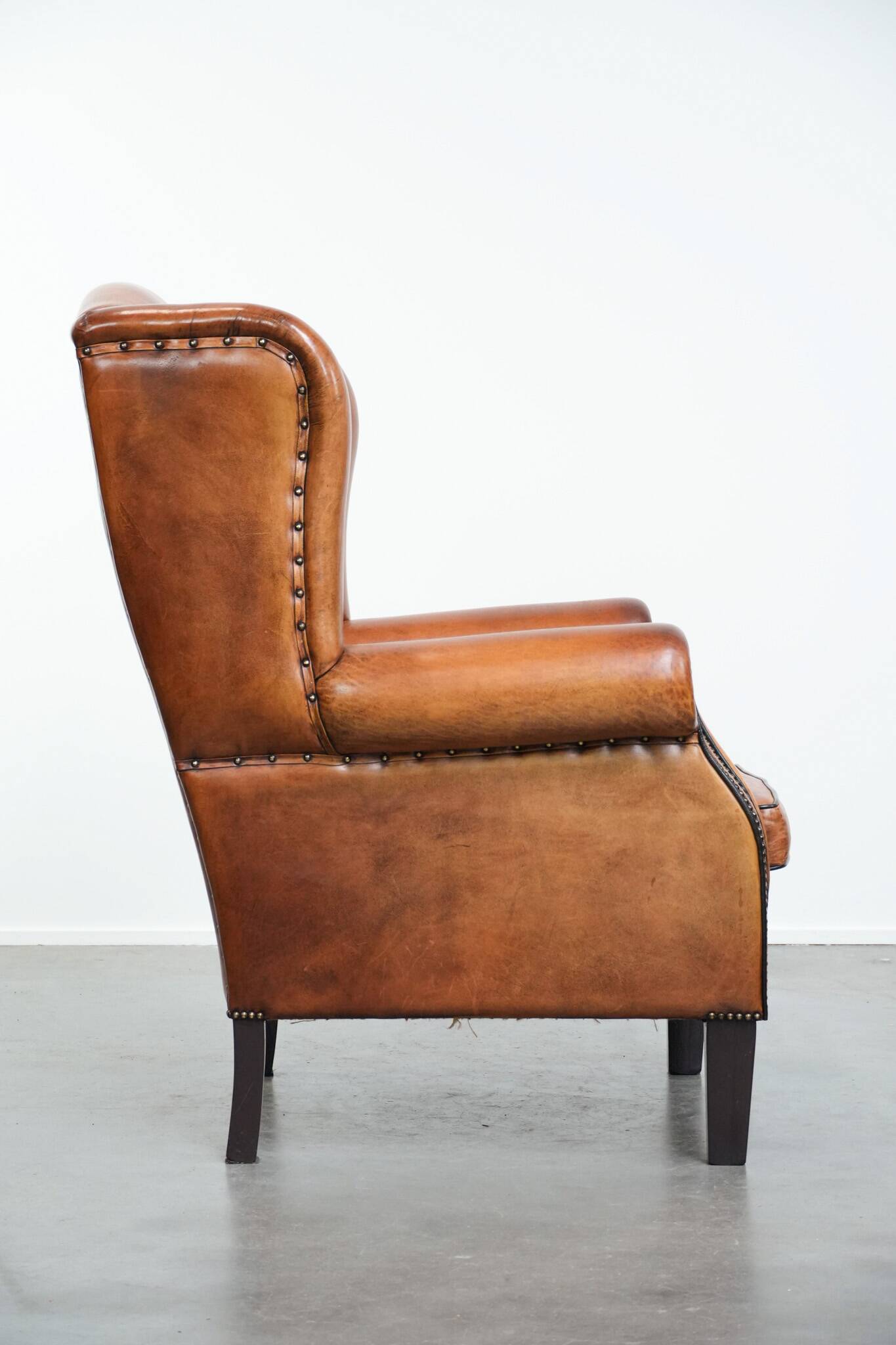 Wingback chair made of sheep leather with black piping in good condition