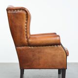 Wingback chair made of sheep leather with black piping in good condition