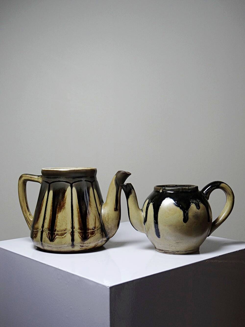 A pair of small vintage teapots in the Art Deco style reminiscent of Denbac.