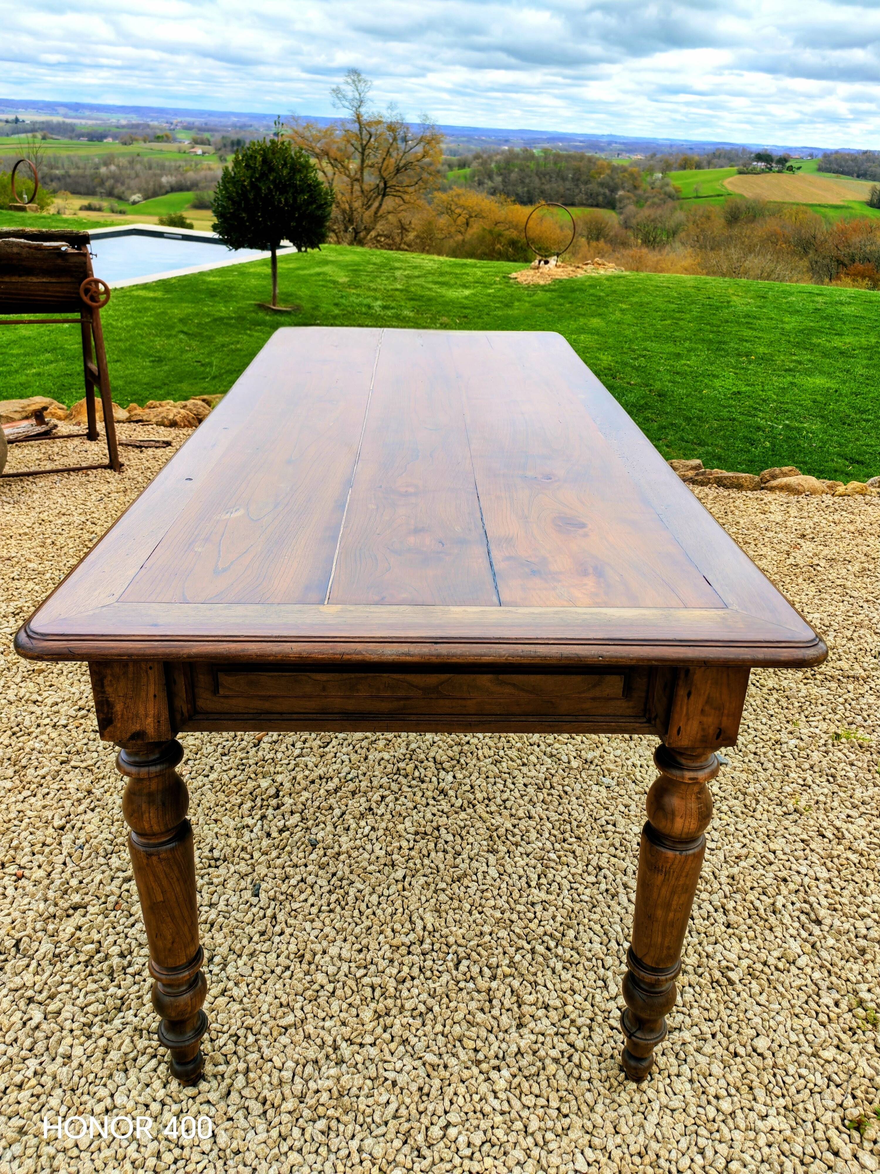 Old French farmhouse table in walnut with turned legs.