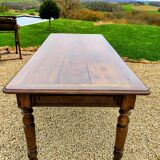 Old French farmhouse table in walnut with turned legs.