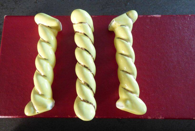 12 yellow and gold ceramic knife rests in their case from the 1950s.