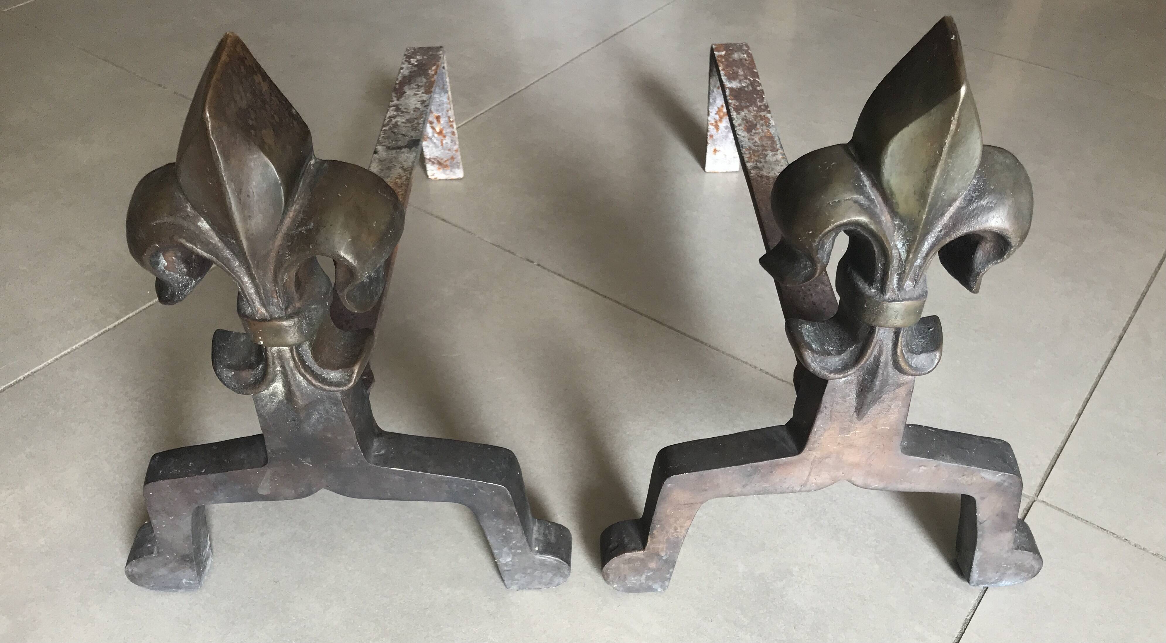 Pair of bronze fireplace firedogs with fleur-de-lys decor, art deco