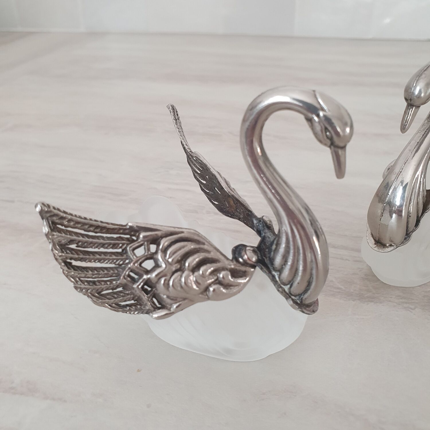 Two frosted glass swan salt cellars with silver plating.