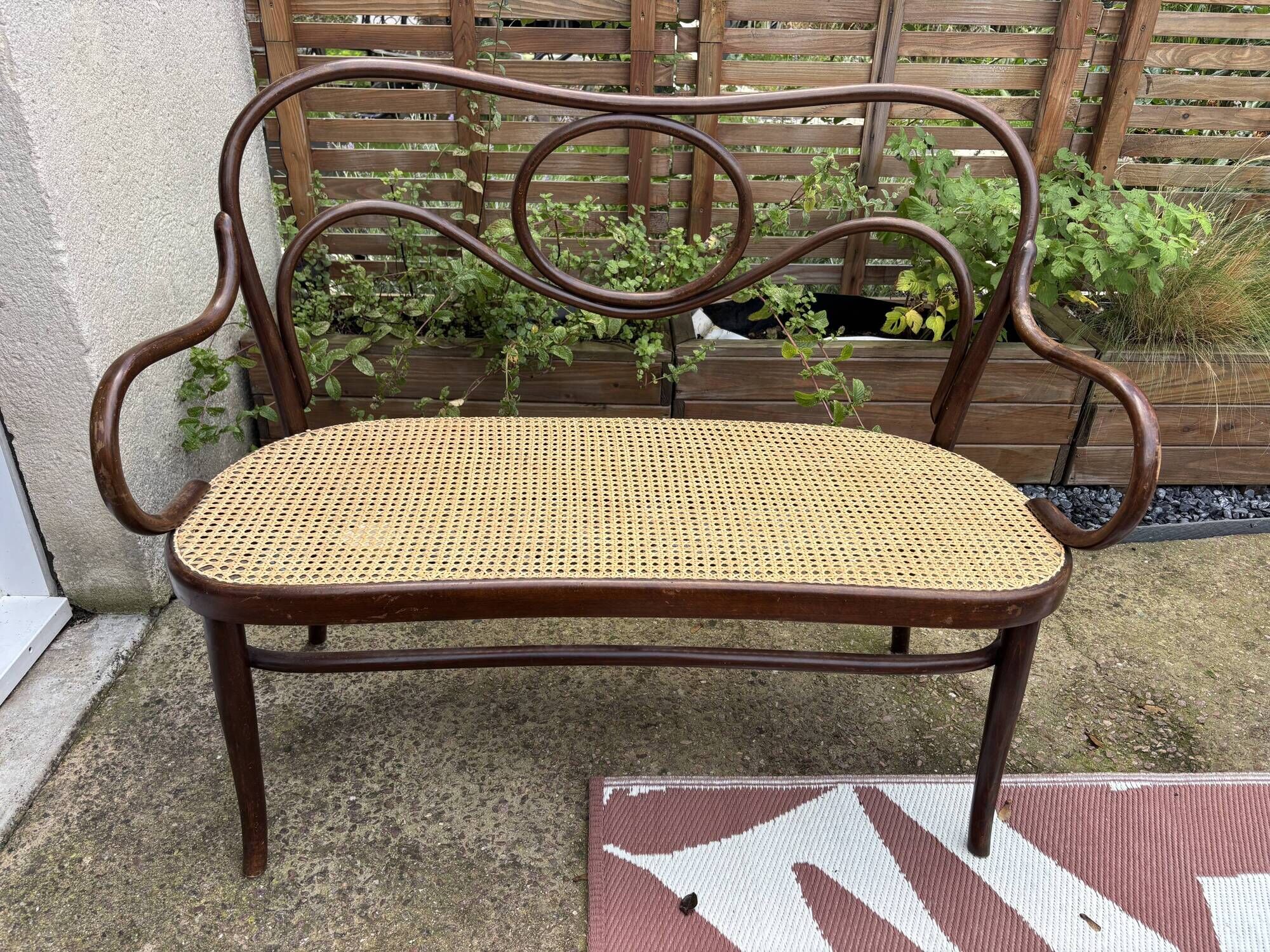 Antique Thonet bench in bent wood and caning, signed.