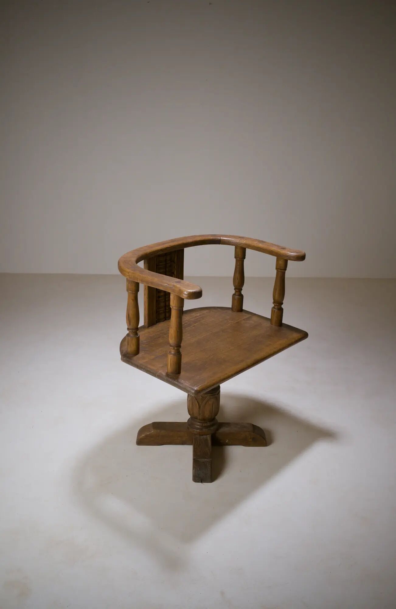 Swivel armchair in carved oak with ball bearings, early 20th century.