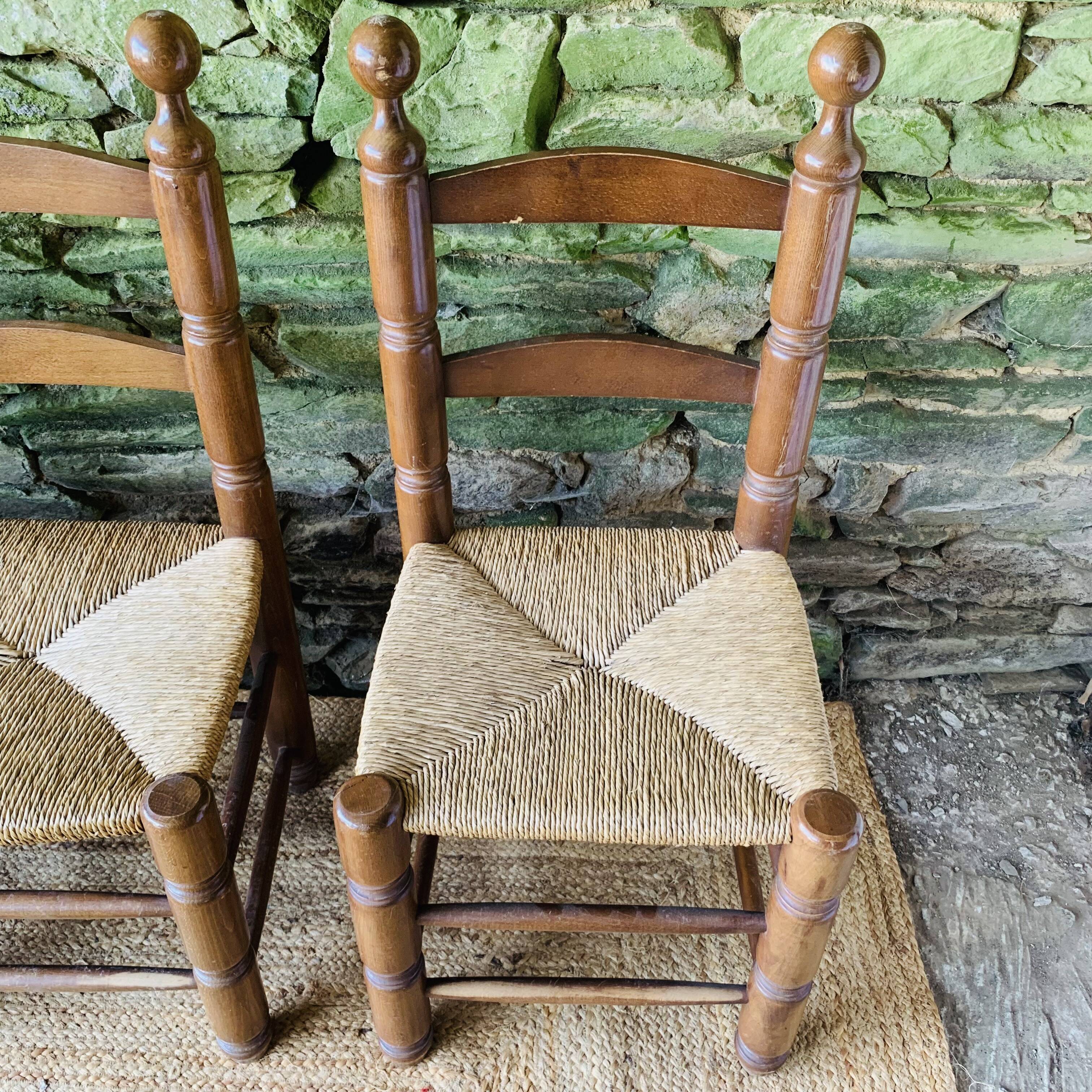 Set of 4 solid wood chairs with straw seats.